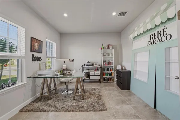 a work room with furniture a rug and a window