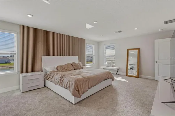 a spacious bedroom with a bed and a cabinets
