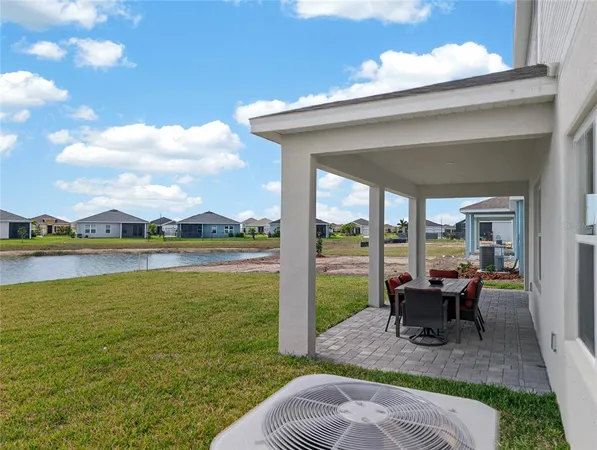 a view of a patio with lawn chairs floor to ceiling window and yard