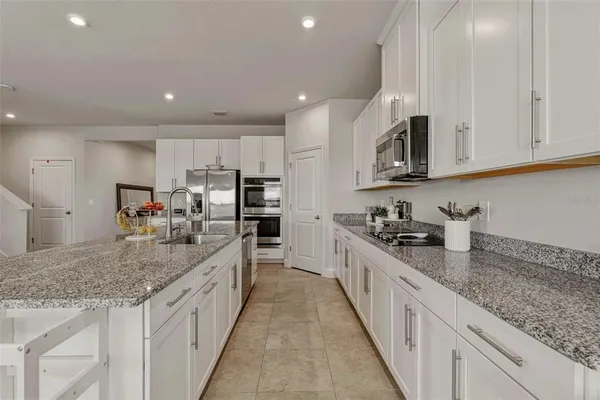 a large kitchen with stainless steel appliances granite countertop a lot of counter space