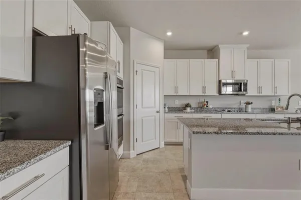 a kitchen with stainless steel appliances granite countertop a refrigerator and a sink