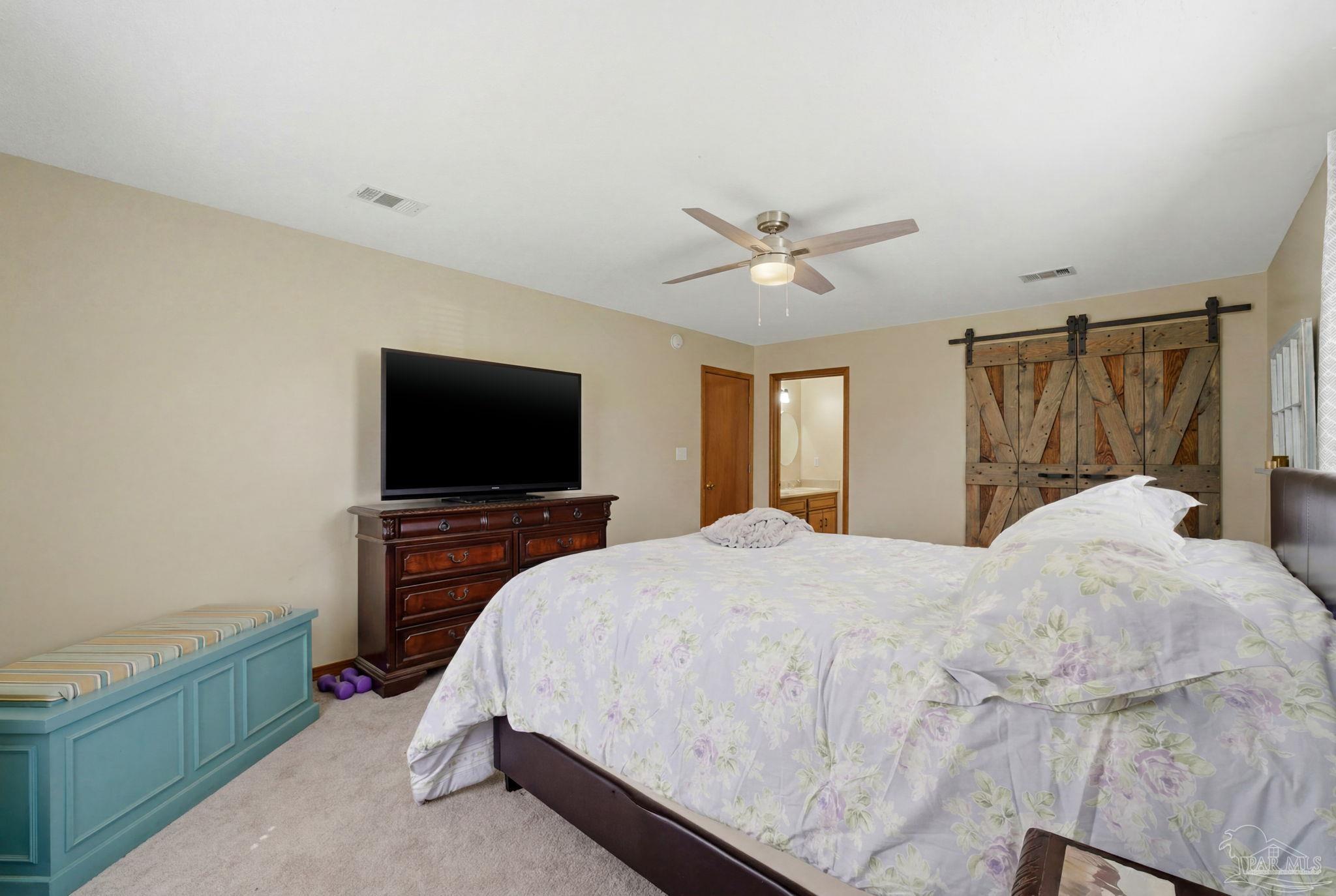 6870 Martin Road Milton, FL 32570 - Photo 32 of 48 a bedroom with a bed and a flat screen tv