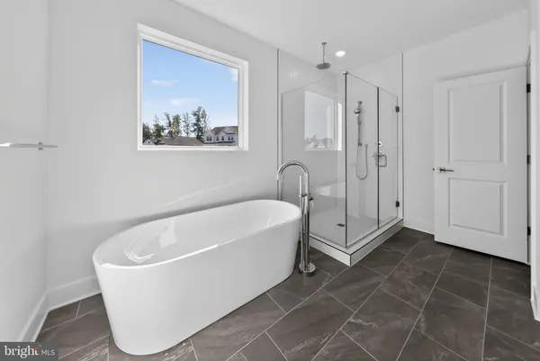 a white bath tub sitting in a spacious bathroom