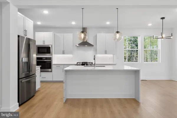 a kitchen with stainless steel appliances granite countertop a refrigerator a sink and a oven