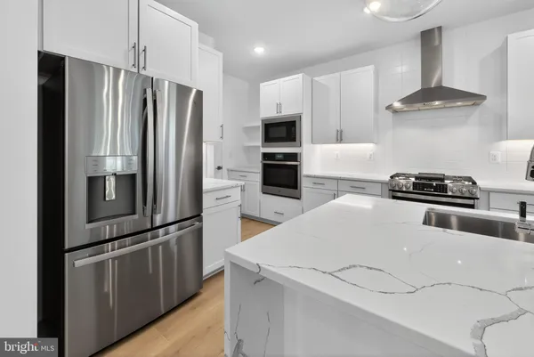 a kitchen with stainless steel appliances a refrigerator and a stove top oven