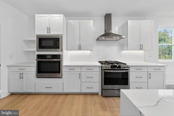 a kitchen with stainless steel appliances a stove a microwave and cabinets