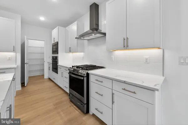 a kitchen with granite countertop a sink stainless steel appliances and cabinets