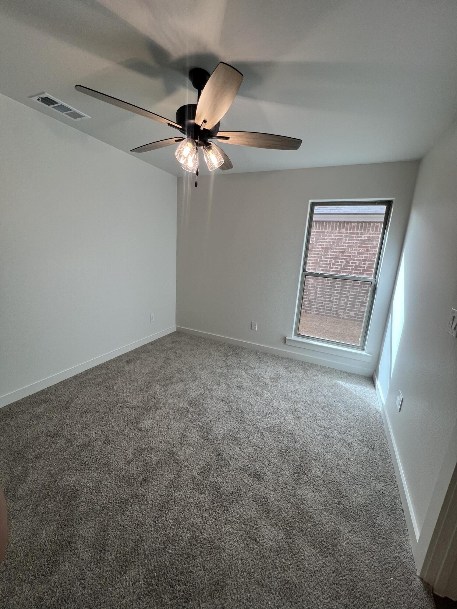 3105 140th Street Lubbock, TX 79423 - Photo 11 of 23 an empty room with windows and fan