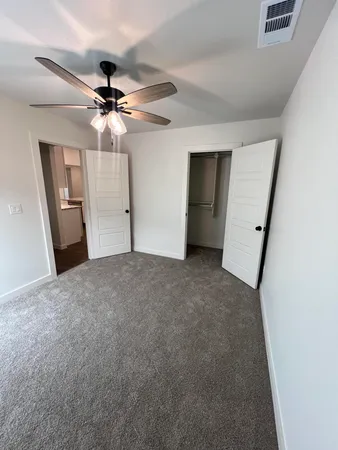 a view of a livingroom with a ceiling fan and window
