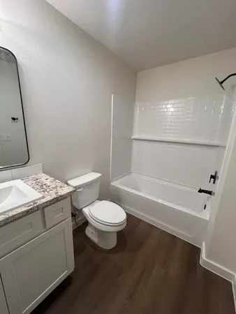 a bathroom with a granite countertop sink toilet and shower