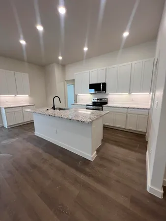 a large kitchen with kitchen island a sink stainless steel appliances and cabinets
