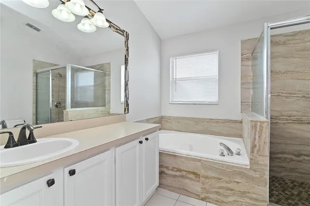 a bathroom with a tub a sink and a large mirror