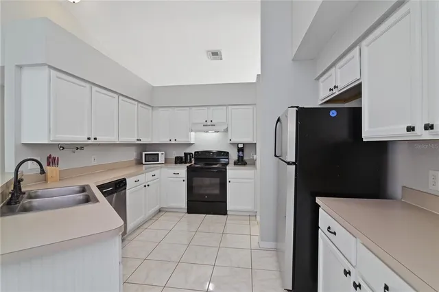 a kitchen with a sink a refrigerator and cabinets