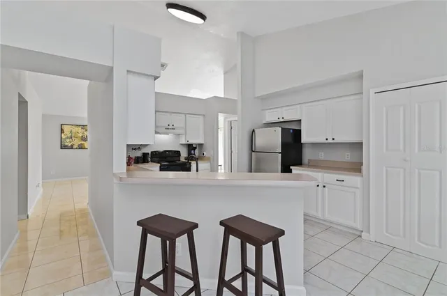 a kitchen with stainless steel appliances white cabinets and chairs