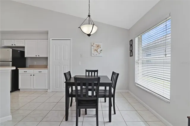 a view of a dining room with furniture and kitchen view