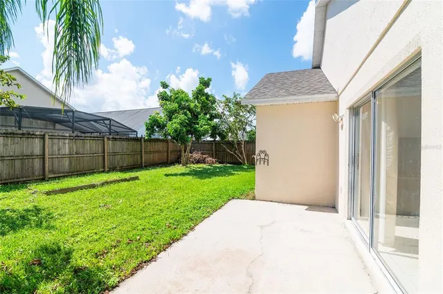 a backyard of a house with plants and palm trees