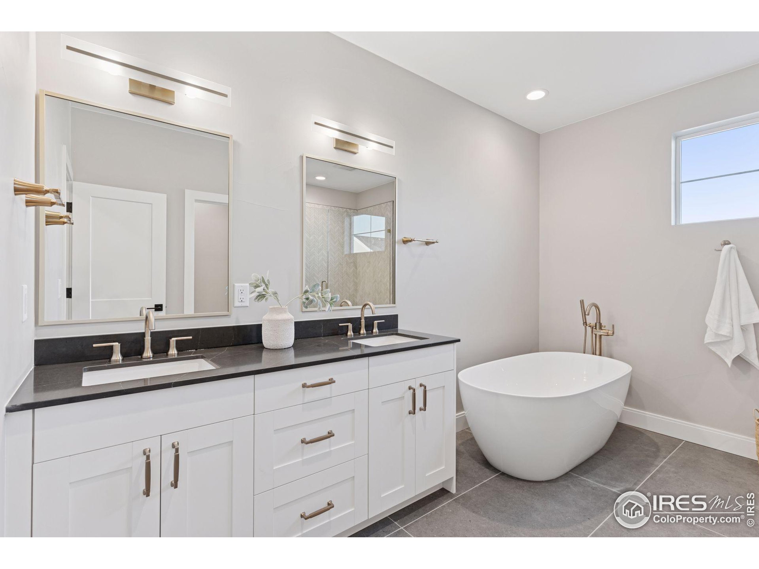 927 William Way Berthoud, CO 80513 - Photo 15 of 28 a spacious bathroom with a double vanity sink and a mirror