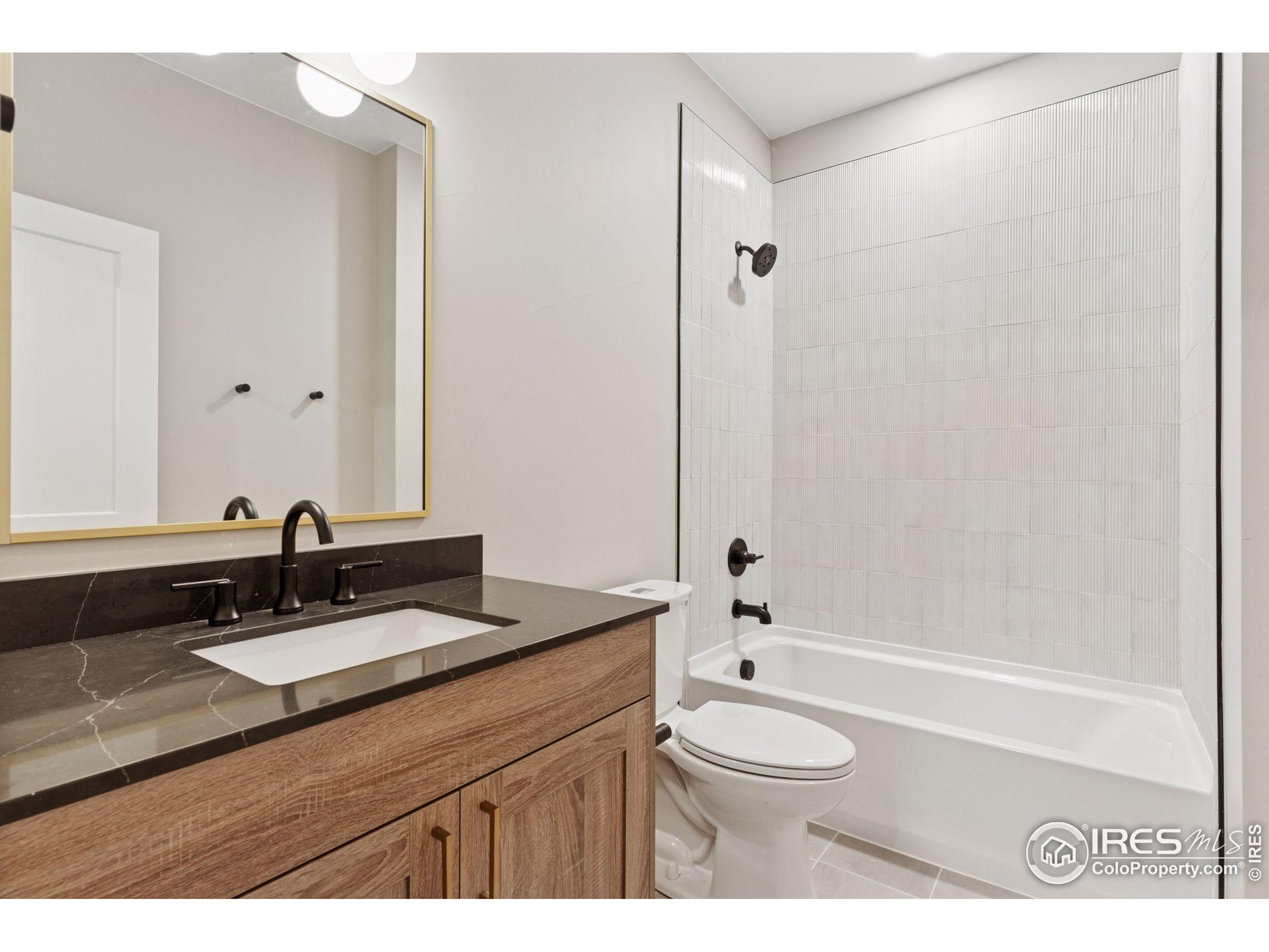 927 William Way Berthoud, CO 80513 - Photo 24 of 28 a bathroom with a granite countertop sink a toilet a mirror and shower