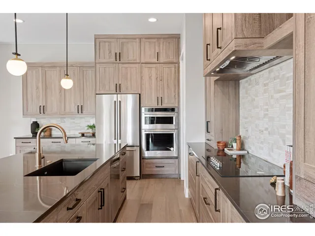 a large kitchen with kitchen island a large counter top a sink a stove and a refrigerator