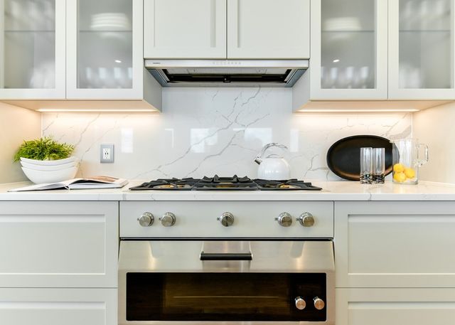 a stove top oven sitting inside of a kitchen