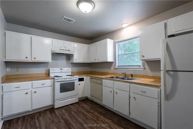 a kitchen with white cabinets and white appliances
