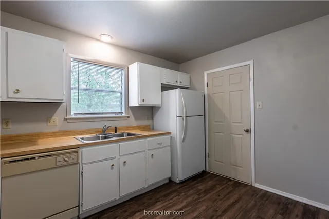 a kitchen with white cabinets and white appliances