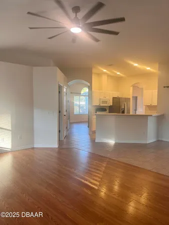 a view of a living room a kitchen and a hard wood floor
