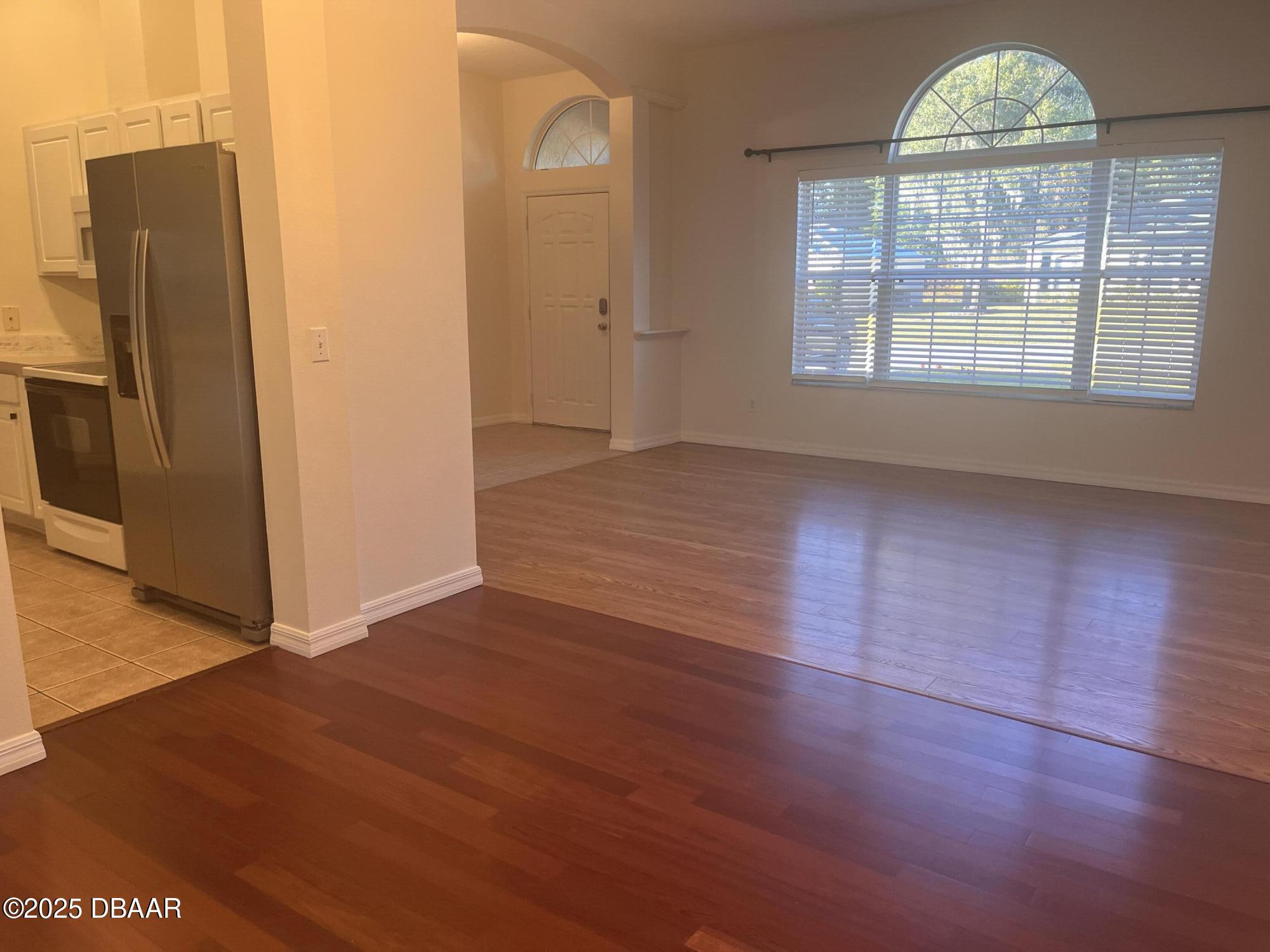 612 John Thomas Avenue DeLand, FL 32724 - Photo 5 of 11 an empty room with wooden floor cabinet and windows