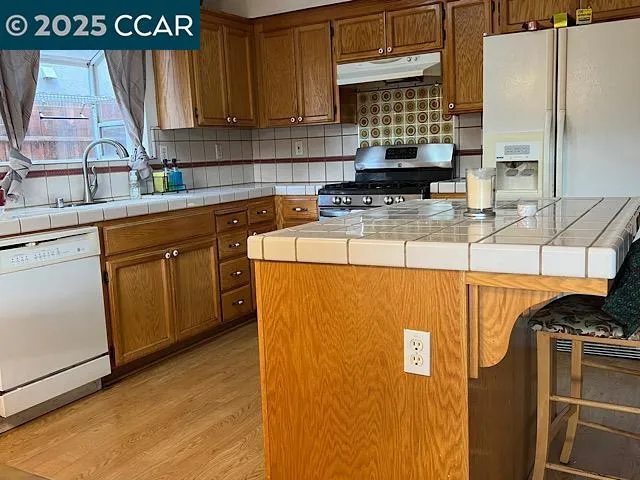 a kitchen with stainless steel appliances granite countertop a sink a stove and a refrigerator