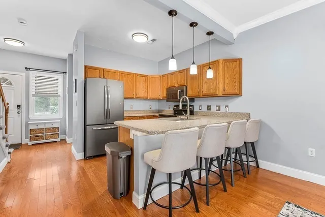 a kitchen with stainless steel appliances a table chairs refrigerator and microwave