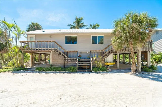 a view of a house with a yard and potted plants