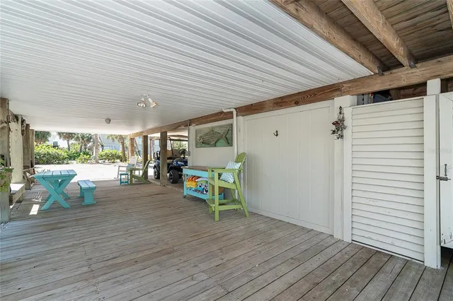 a view of a patio with table and chairs with wooden floor and fence