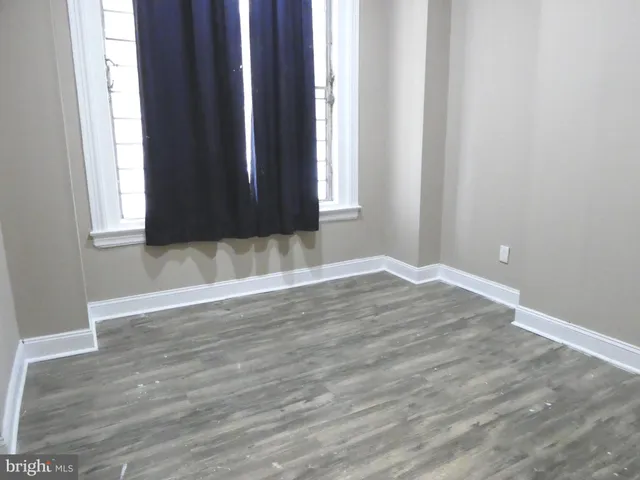 a view of wooden floor and window in an empty room