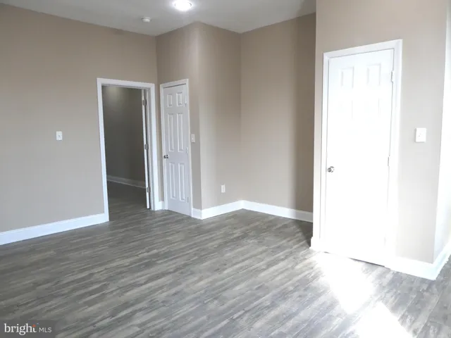 an empty room with wooden floor & closet