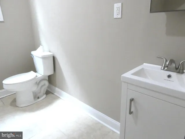 a bathroom with a sink toilet and a mirror