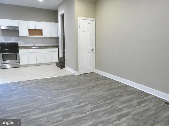 a view of a kitchen with wooden floor and a sink