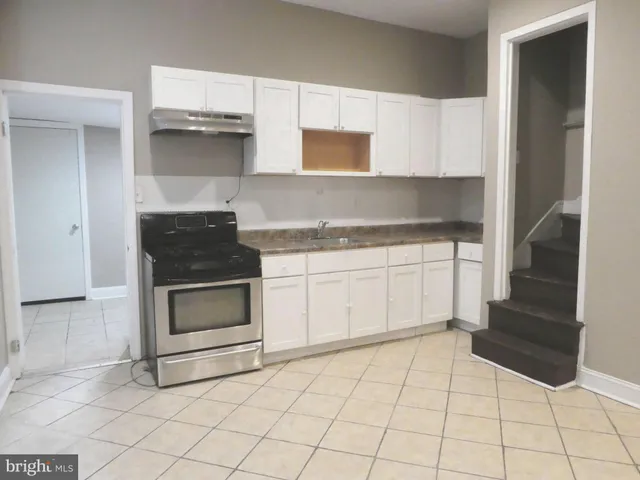 a kitchen with white cabinets and appliances