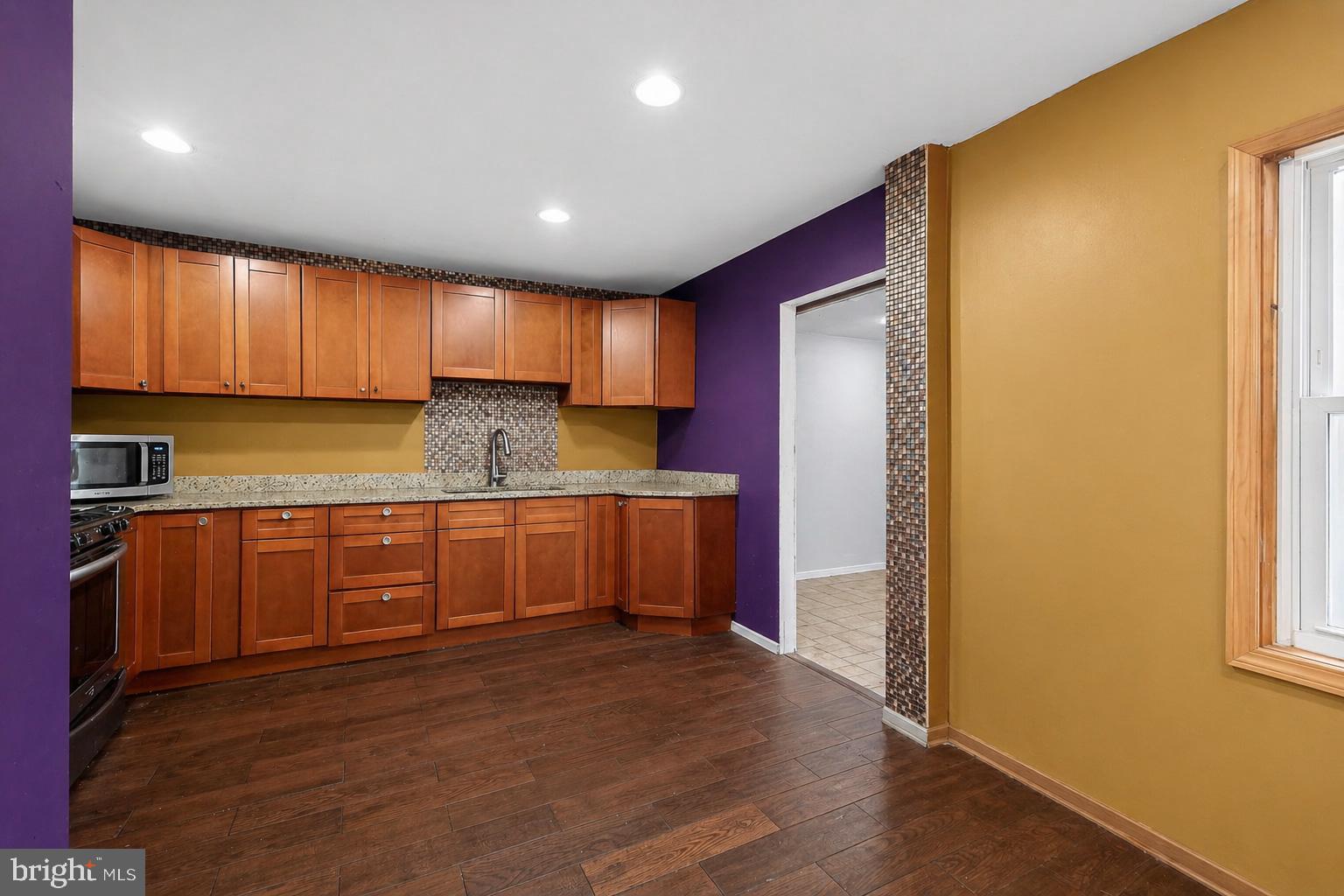 4516 Yates Road Beltsville, MD 20705 - Photo 4 of 31 a kitchen with granite countertop wooden cabinets a sink a stove a refrigerator and dishwasher with wooden floor