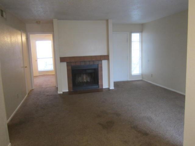 12480 Abrams Road, Unit 521 Dallas, TX 75243 - Photo 19 of 26 Carpeted interior with a brick-surround fireplace and a wood mantel