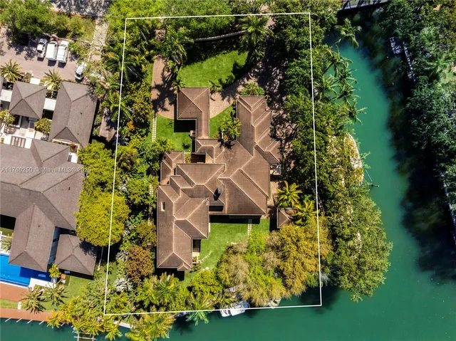 an aerial view of residential house with outdoor space and trees all around