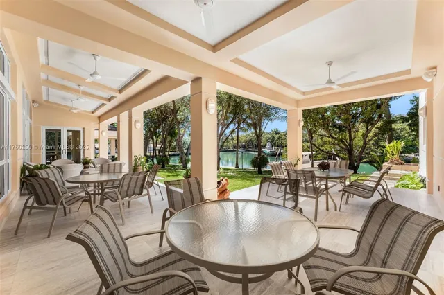 a dining room with furniture large windows and a chandelier