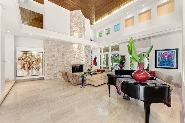 a living room with furniture a fireplace and a floor to ceiling window