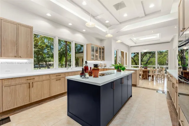 a kitchen with kitchen island a sink a counter top space appliances and a large window