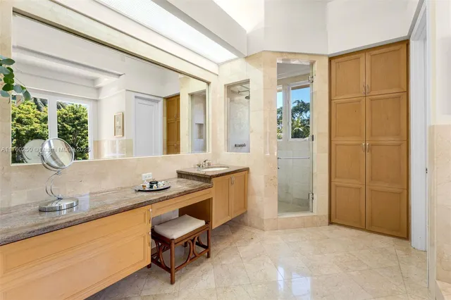 a spacious bathroom with a granite countertop sink a mirror and a bathtub