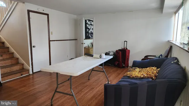 a bed sitting in a bedroom next to a window with wooden floor