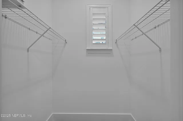 a view of a dining room and livingroom with furniture wooden floor a chandelier