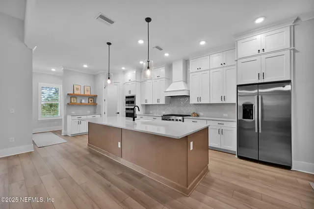 a kitchen with stainless steel appliances a stove and a hard wood floor