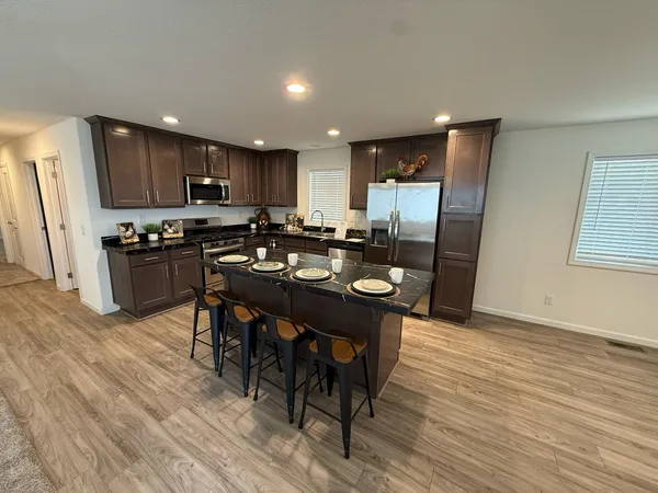 a kitchen with a table chairs refrigerator and microwave