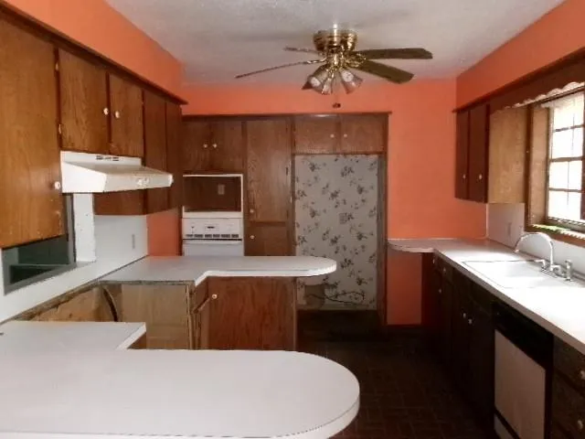 a large kitchen with stainless steel appliances a stove a sink dishwasher and a microwave oven