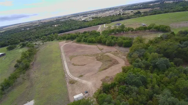 an aerial view of a house with a yard and lake view